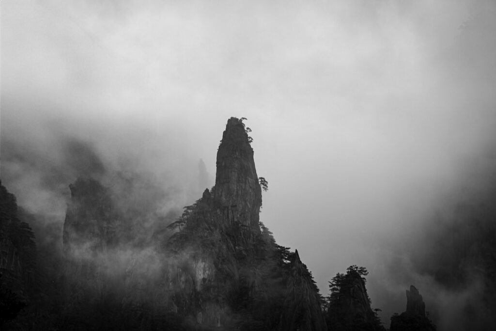 a mountain with fog and trees mount huangshan