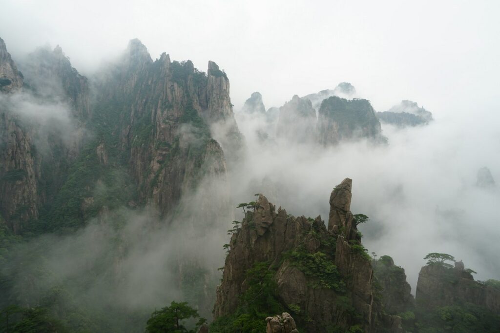 a rocky mountains with fog with Huangshan in the background mount huangshan china