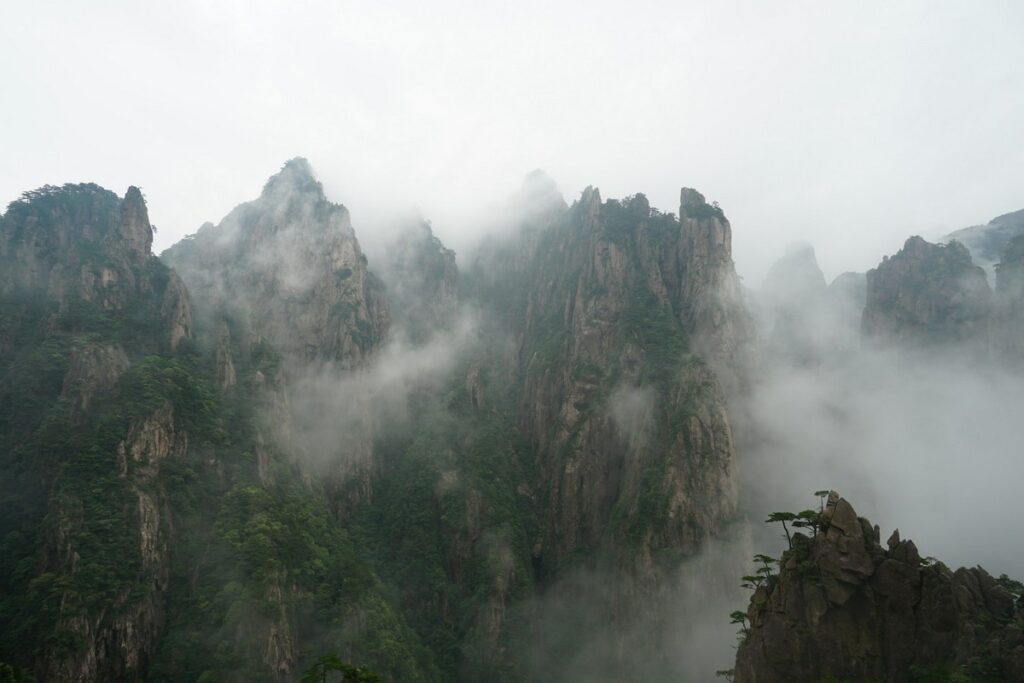 a mountain with fog and trees mount huangshan china