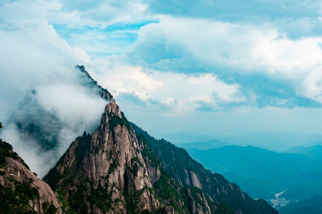 a mountain with clouds and blue sky mount huangshan map