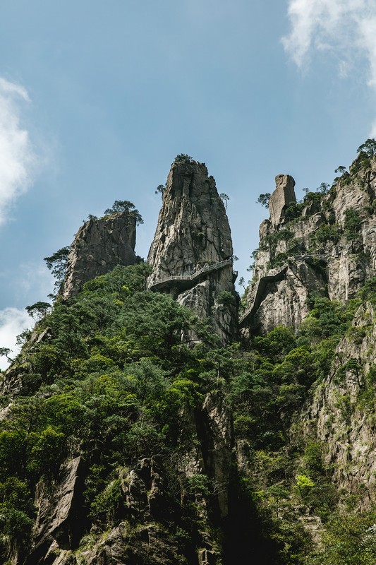 a tall rock mountain with trees yellow mountain anhui china