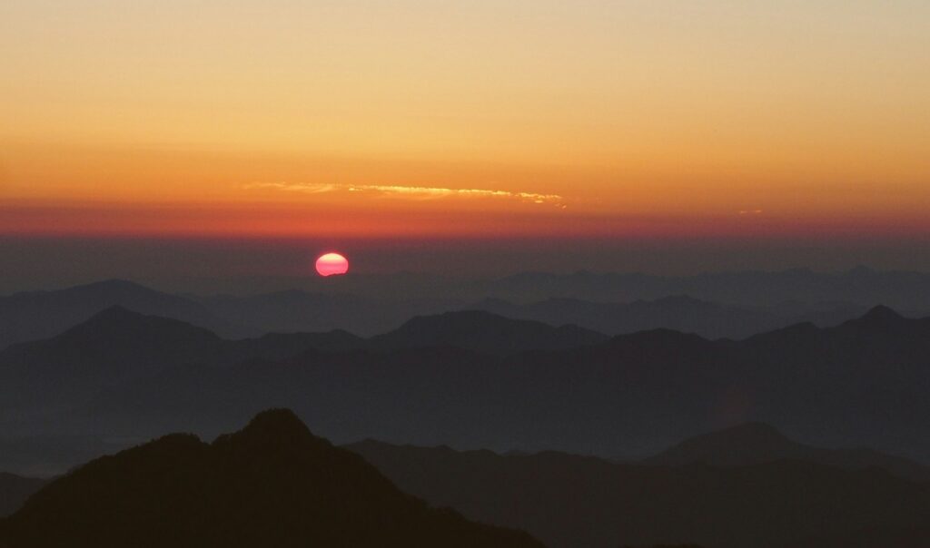 a sunset over mountains yellow mountain china