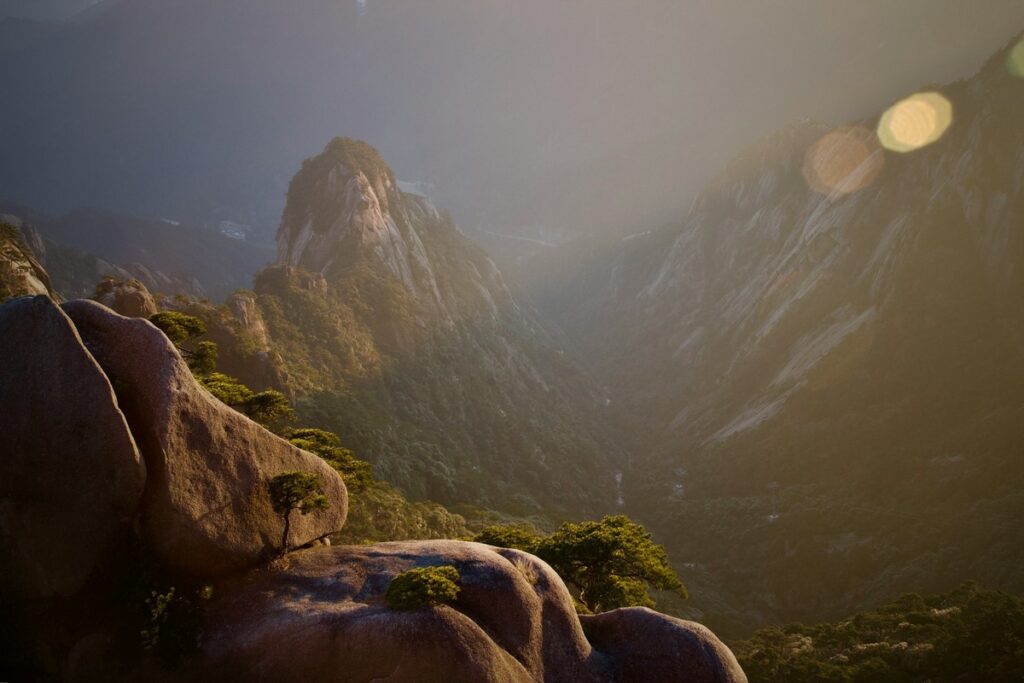 a rocky mountains with trees yellow mountain hike china