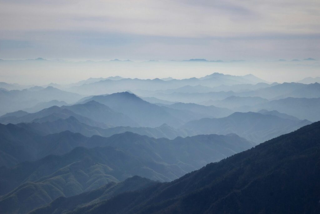 a mountain range with fog yellow mountain hike china