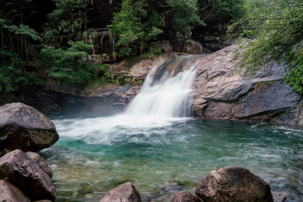 a waterfall in a forest yellow mountain in china