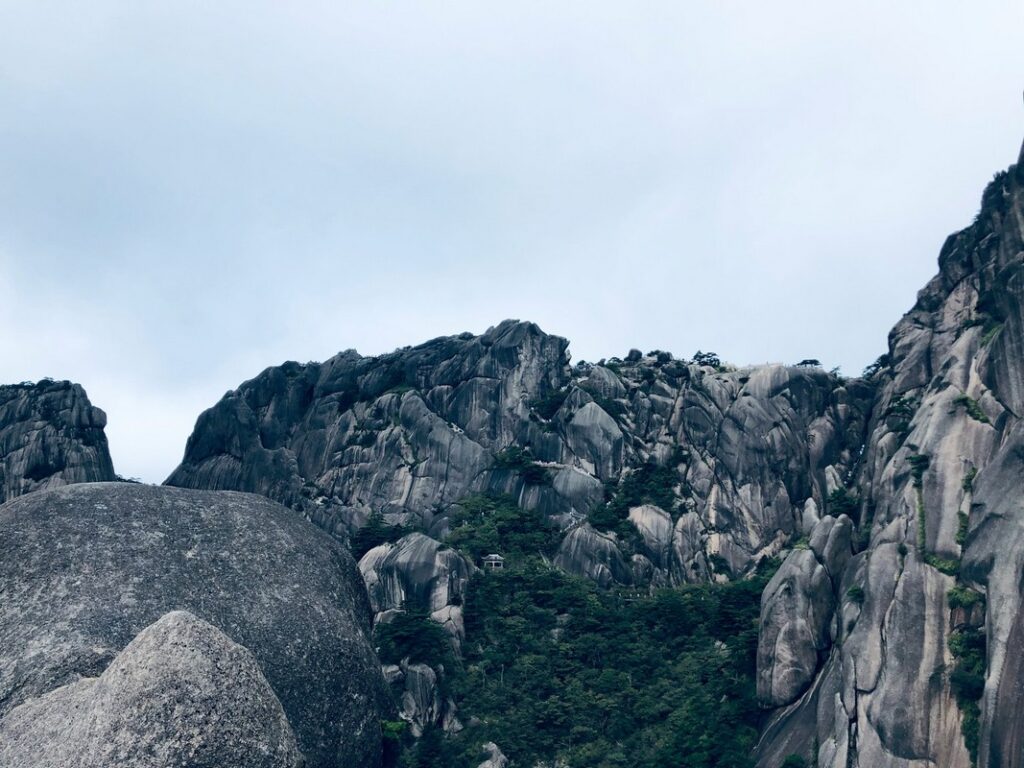 a large rock formation with trees on top yellow mountain in china